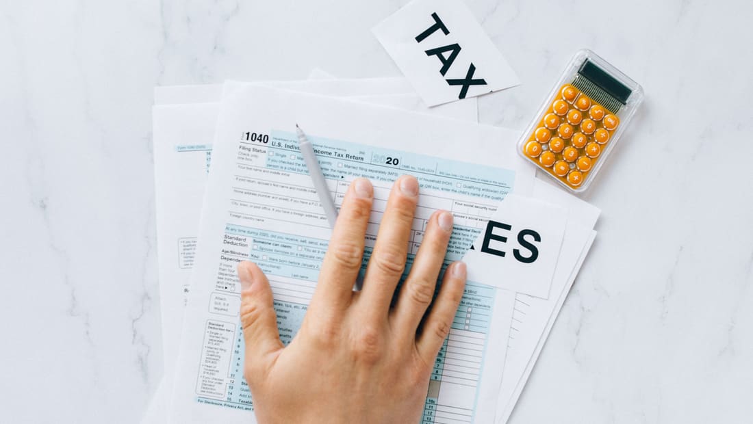 A US 1040 tax form with a calculator