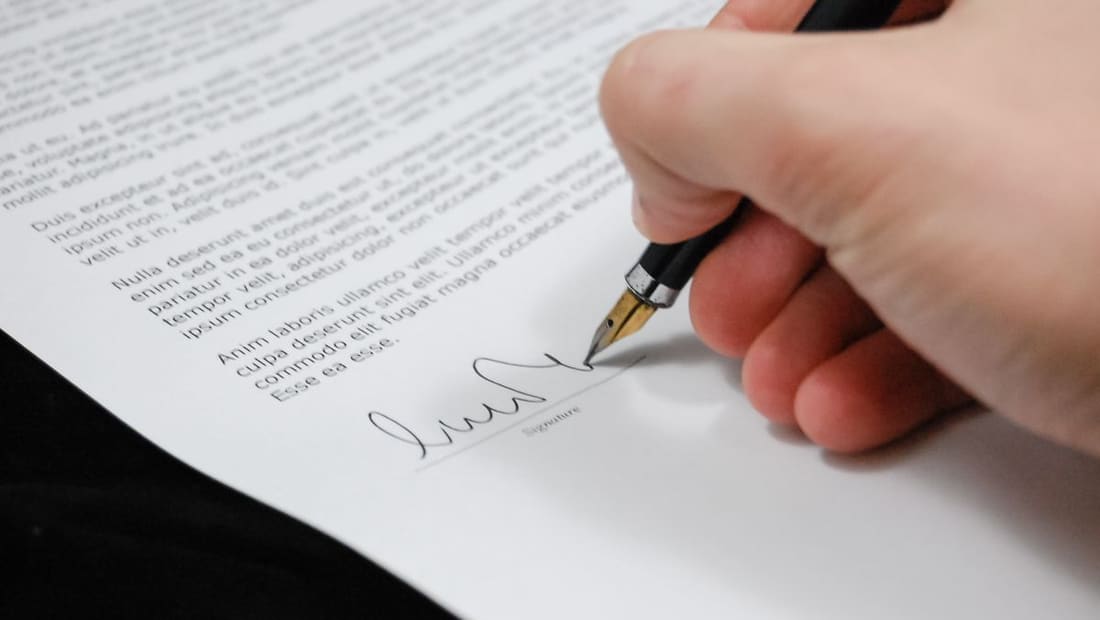 Signing a real estate document with a pen