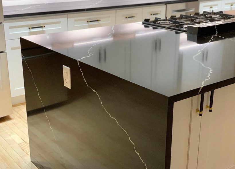 Close-up of a black quartz waterfall kitchen island renovated by House Buyers of Cheyenne