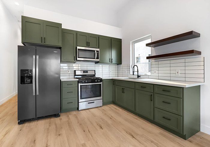 Renovated kitchen with green cabinets by House Buyers of Cheyenne
