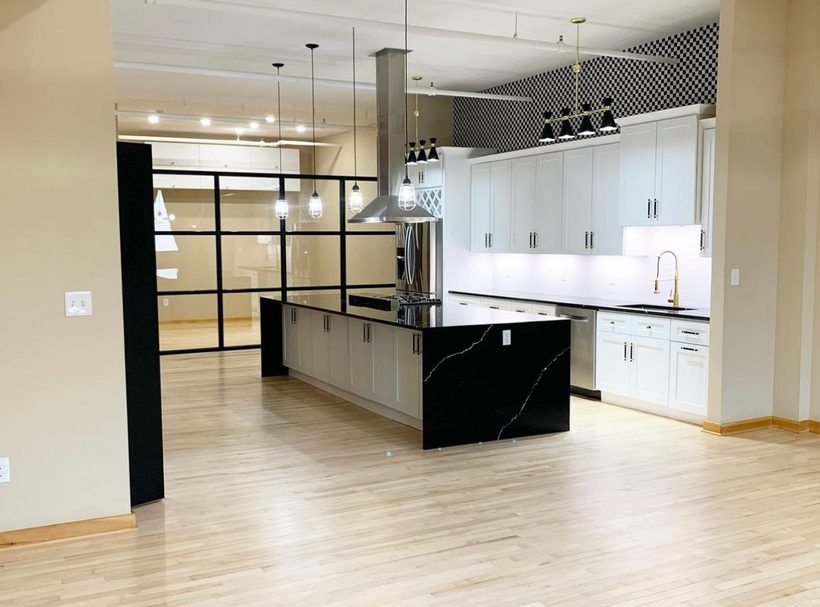Open-concept kitchen with a black quartz waterfall island, renovated by House Buyers of Cheyenne
